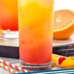 Pinterest graphic for Tequila Sunrise recipe. Image is side view of Tequila Sunrise garnished with orange slice and cherry. Another Tequila Sunrise cocktail and half of an orange on try behind and extra fruit for garnish beside glass. Text says, "Tequila Sunrise simplejoy.com"