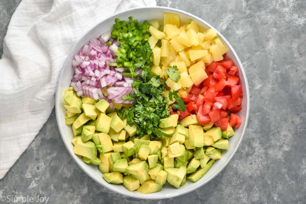 Overhead photo of a bowl of chopped ingredients for Avocado Salsa recipe