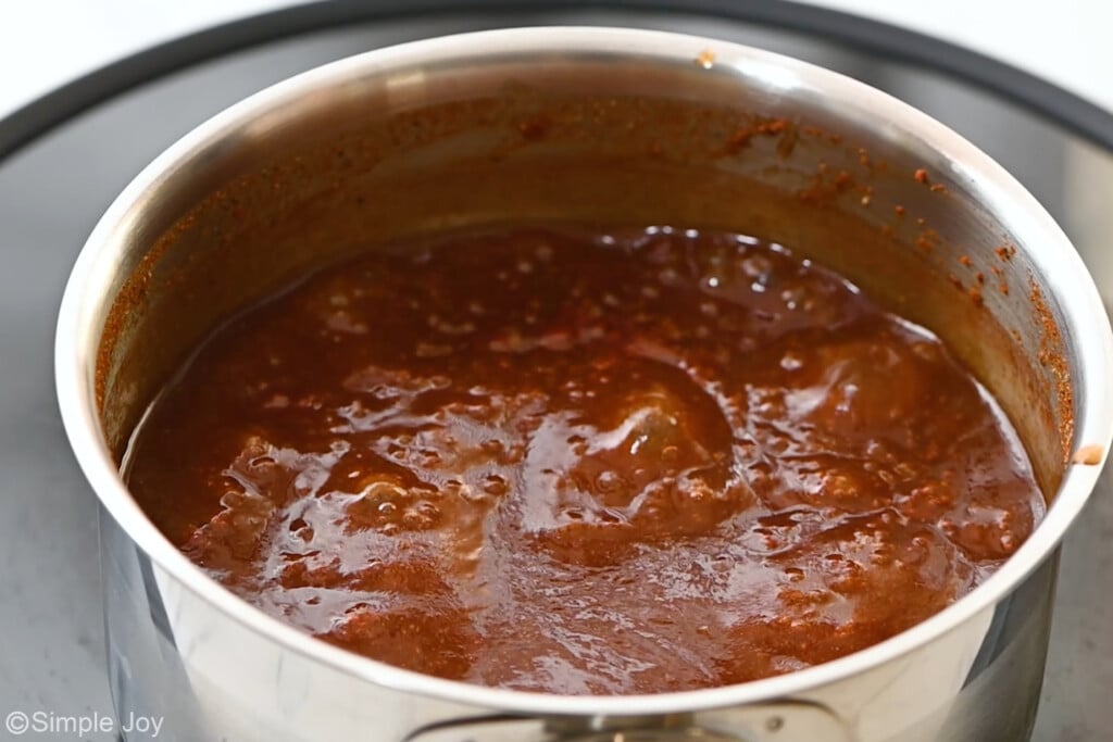 close up of a small sauce pan with simmering bbq sauce