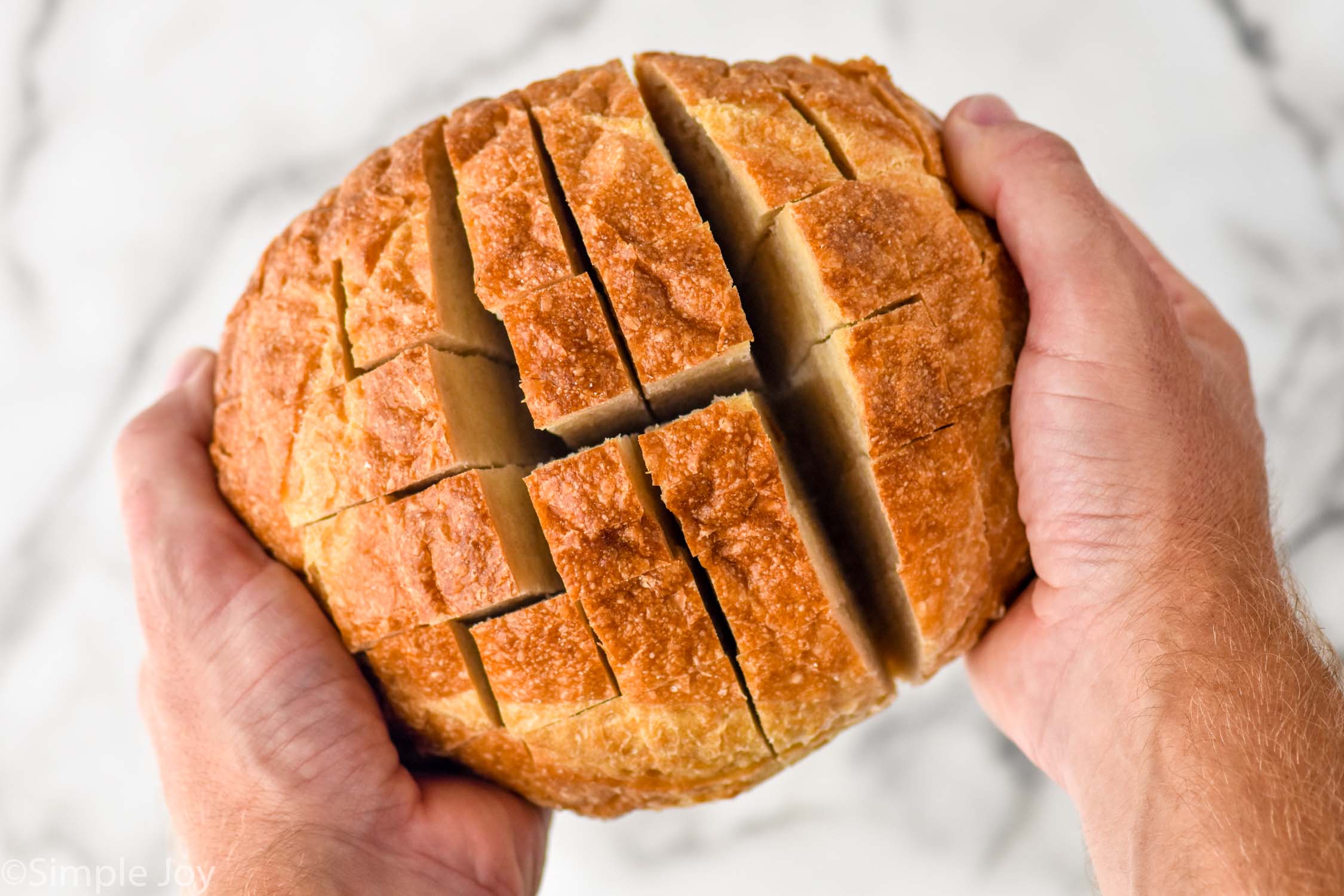 loaf of sourdough bread cut to make Buffalo Pull Apart Bread