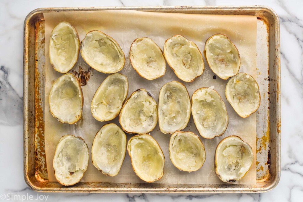 Overhead photo of a baking sheet of emptied potato skins for Potato Skins recipe