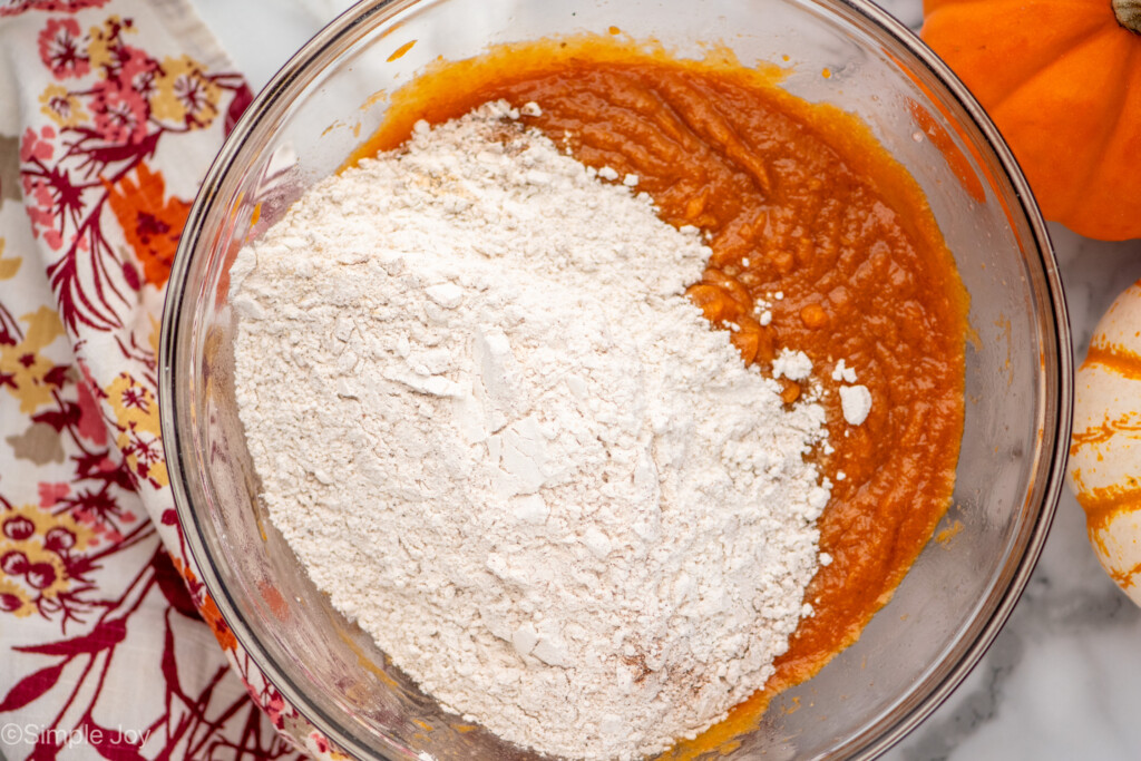 dry ingredients for pumpkin chocolate chip muffins being mixed into the wet ingredients