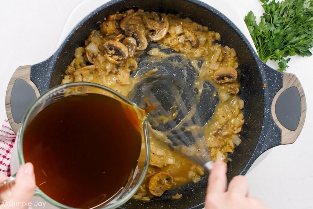 adding beef broth to a skillet to finish off mushroom gravy