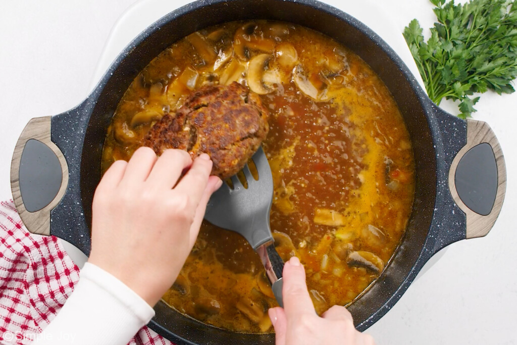 steak being added to gravy to finish cooking