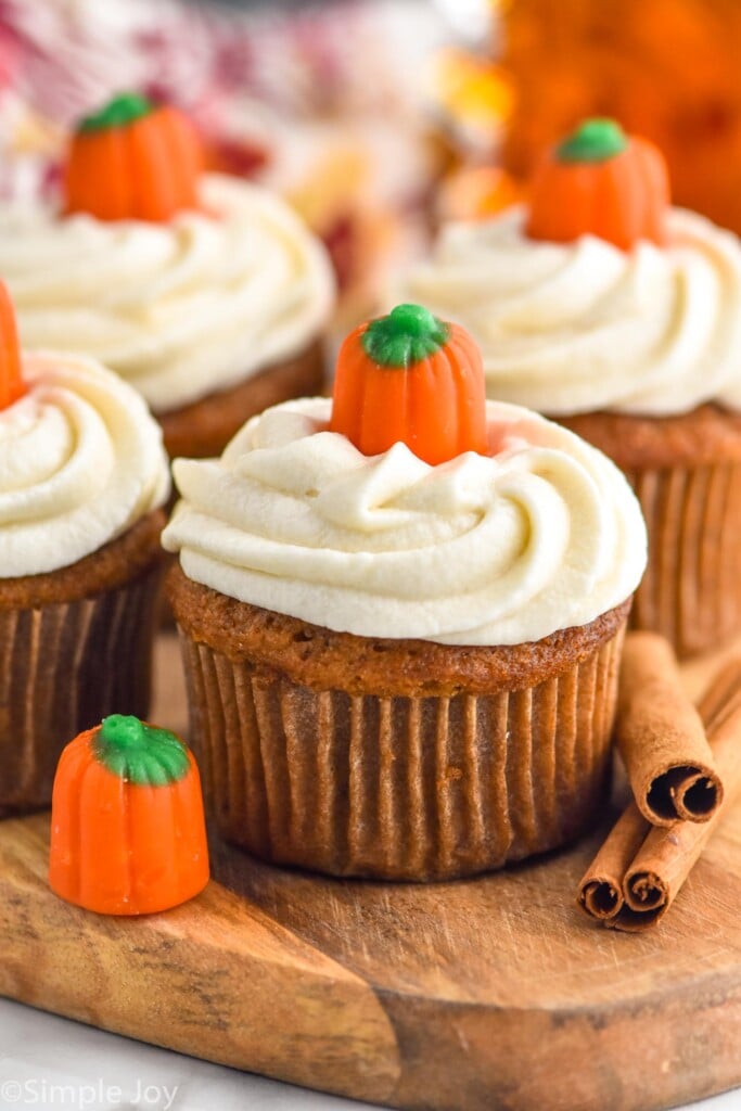Pumpkin cupcakes topped with maple frosting and pumpkin candies.