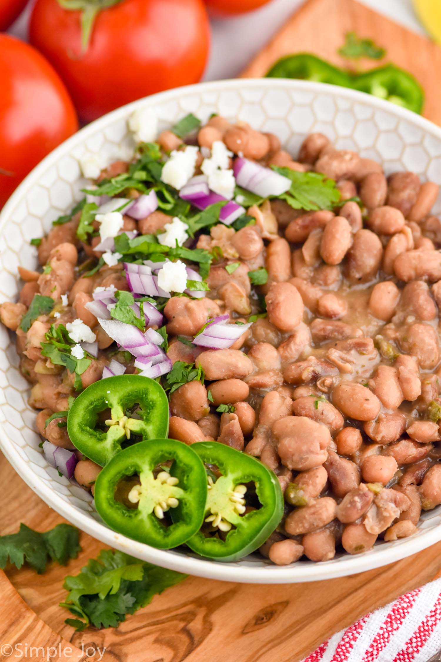 bowl of instant pot pinto beans topped with cilantro, red onion, and cilantro