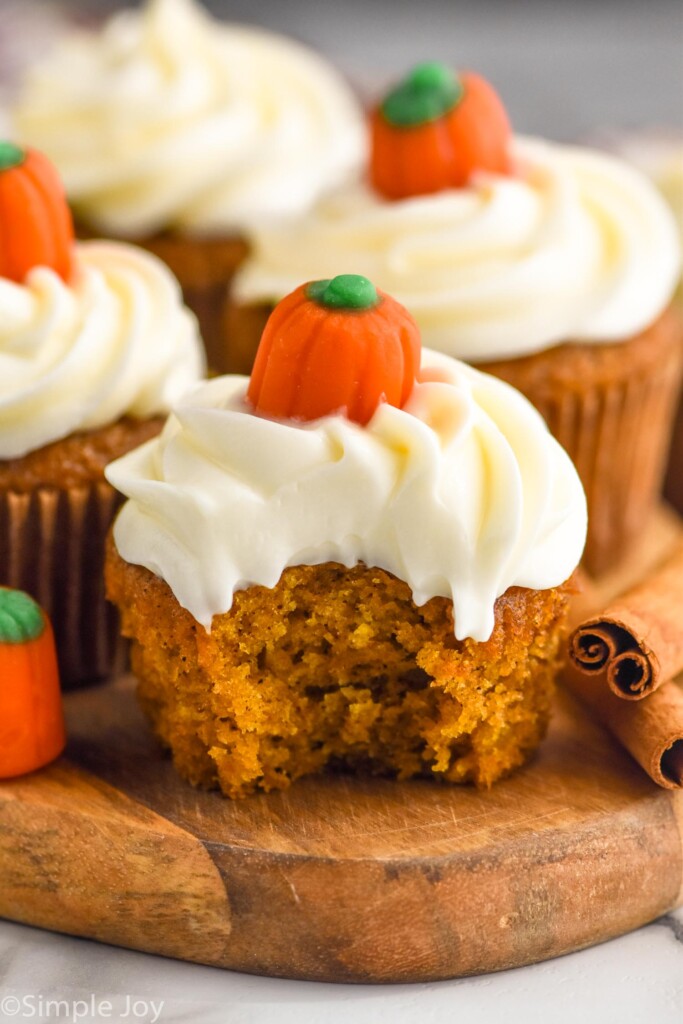 Close up side view of Pumpkin Cupcakes with a bite taken out of the front Pumpkin Cupcake