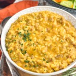 Bowl of Pumpkin Risotto with glass of red wine and bowl of salad sitting in background - 17
