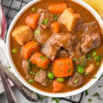 Pinterest graphic for Beef Stew recipe. Overhead photo of bowls of Beef Stew with bread beside. Text says, "super easy Beef Stew recipe simplejoy.com"