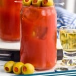 Pinterest graphic for Bloody Mary recipe. Image shows a Bloody Mary garnished with olives, pickles, and celery. Olive spear and shot of beer beside. Text says, "Bloody Mary simplejoy.com."