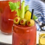 Pinterest graphic for Bloody Mary recipe. Text says, "the best Bloody Mary simplejoy.com." Image shows a Bloody Mary garnished with olives, pickles, and celery.