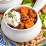 Pinterest graphic for butternut squash chili. Image shows two bowls of butternut squash chili topped with sour cream. Text says "butternut squash chili simplejoy.com"