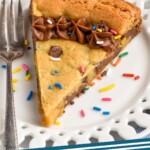 Pinterest graphic for Cookie Cake recipe. Image shows a slice of Cookie Cake on a plate with a fork. Text says, "Cookie Cake simplejoy.com"