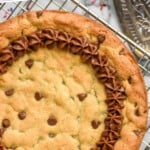 Pinterest graphic for Cookie Cake recipe. Text says, "the best Cookie Cake simplejoy.com." Image shows Cookie Cake on a cooling rack with sprinkles beside.