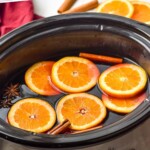 Pinterest graphic for Slow Cooker Mulled Wine recipe. Text says, "slow cooker mulled wine simplejoy.com." Image shows a crock pot of Slow Cooker Mulled Wine.