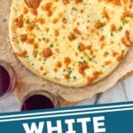 Pinterest graphic for white pizza sauce. overhead of pizza with white pizza sauce. White sauce and two glasses of red wine sitting beside pizza. Text says "white pizza sauce simplejoy.com"