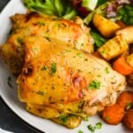 Photo of Baked Chicken Thighs served on a plate with veggies and side salad