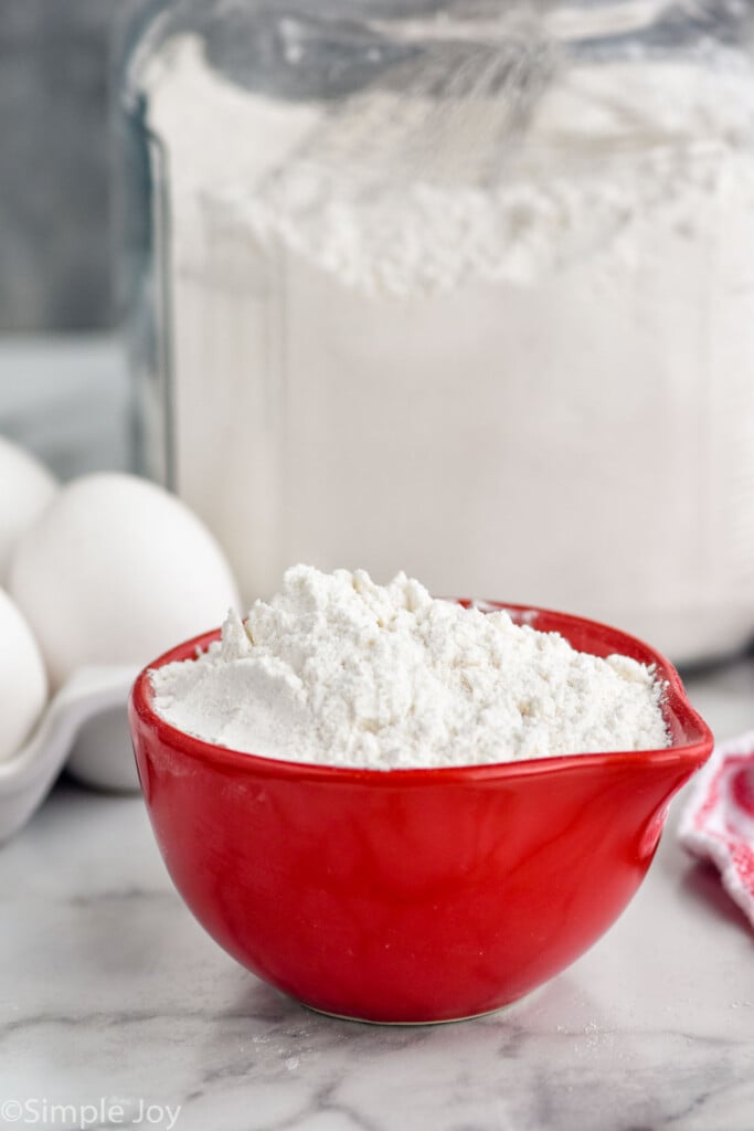 bowl of homemade pancake mix with container of pancake mix and eggs sitting in background