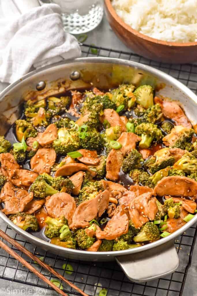 Photo of a pan of Chicken and Broccoli Recipe. Bowl of rice beside