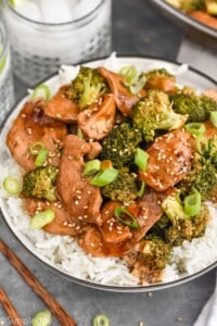 Plate of Chicken and Broccoli Recipe served on rice. Drinks beside plate.