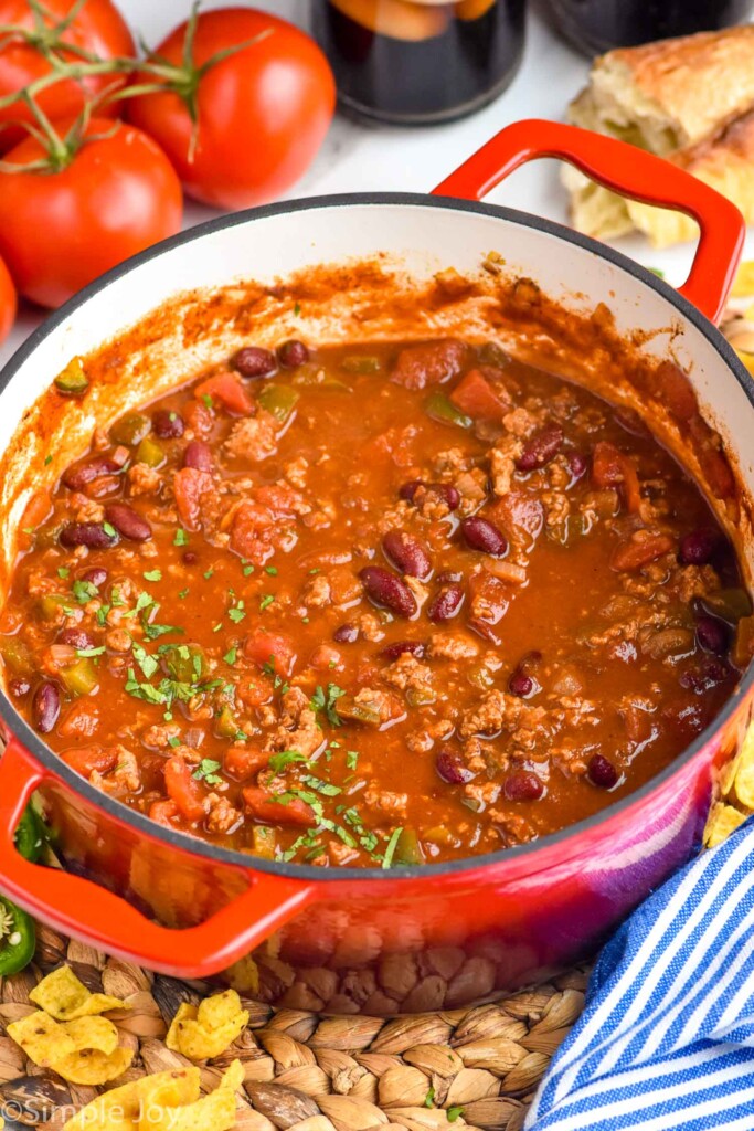 Photo of a pot of Turkey Chili with tomatoes beside