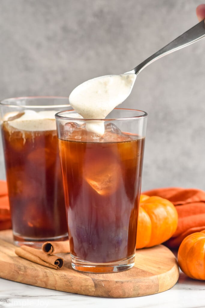 Side view of Pumpkin Cream Cold Brew being spooned on top of glass of cold brew.