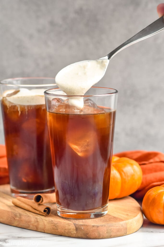 Side view of Pumpkin Cream Cold Brew being spooned on top of glass of cold brew.