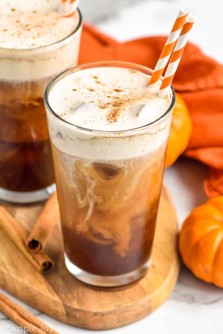 Photo of Pumpkin Cream Cold Brew with cinnamon sticks and pumpkin beside