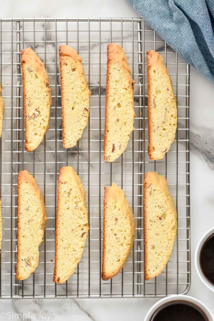 Overhead photo of Biscotti on cooling rack with cups of coffee beside