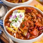 Photo of two bowls of Turkey Chili. Chips and spoon beside. - 8