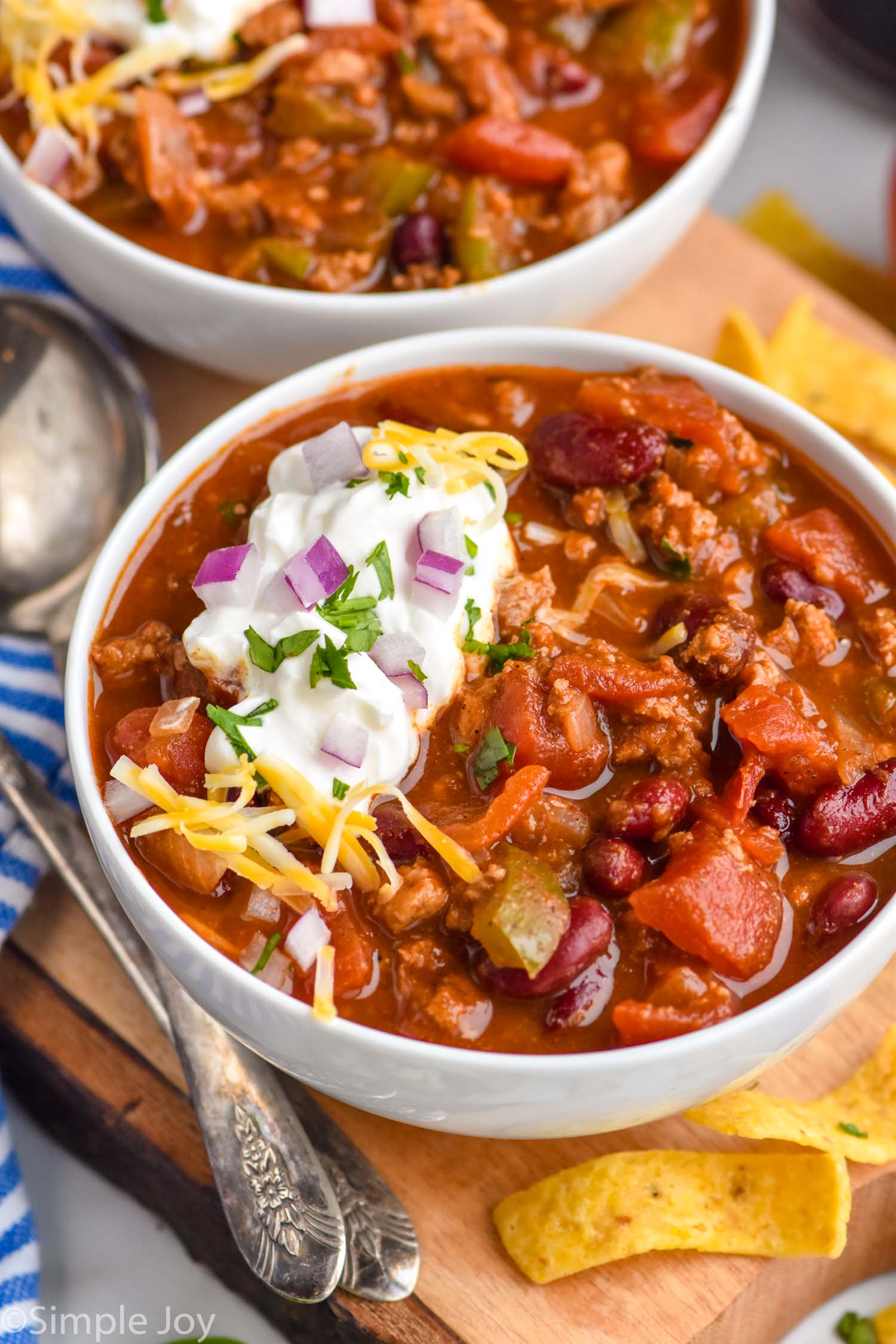 Photo of two bowls of Turkey Chili. Chips and spoon beside.