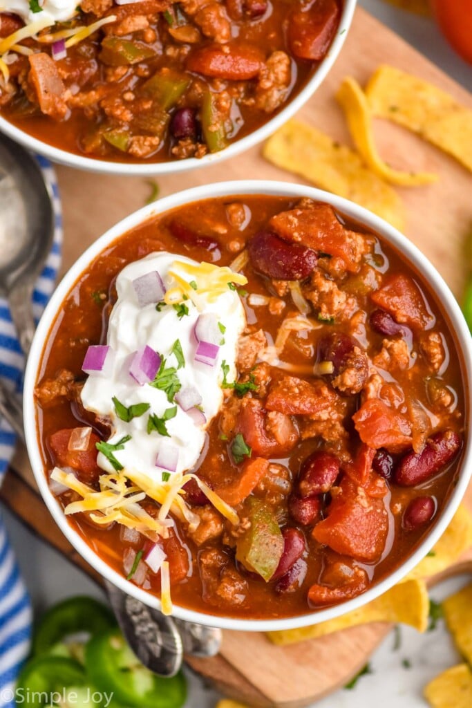 Overhead photo of bowls of Turkey Chili. Chips for garnish beside bowls.