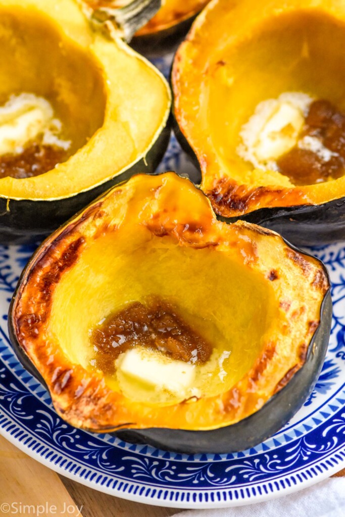 Roasted Acorn Squash on a plate with butter and brown sugar