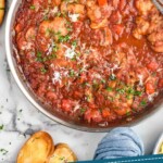 Pinterest graphic for Chicken Cacciatore. Images shows overhead of pan of Chicken Cacciatore with bowl of salad, glass of red wine, and piece of garlic toast sitting beside. Text says "easy homemade chicken cacciatore simplejoy.com"