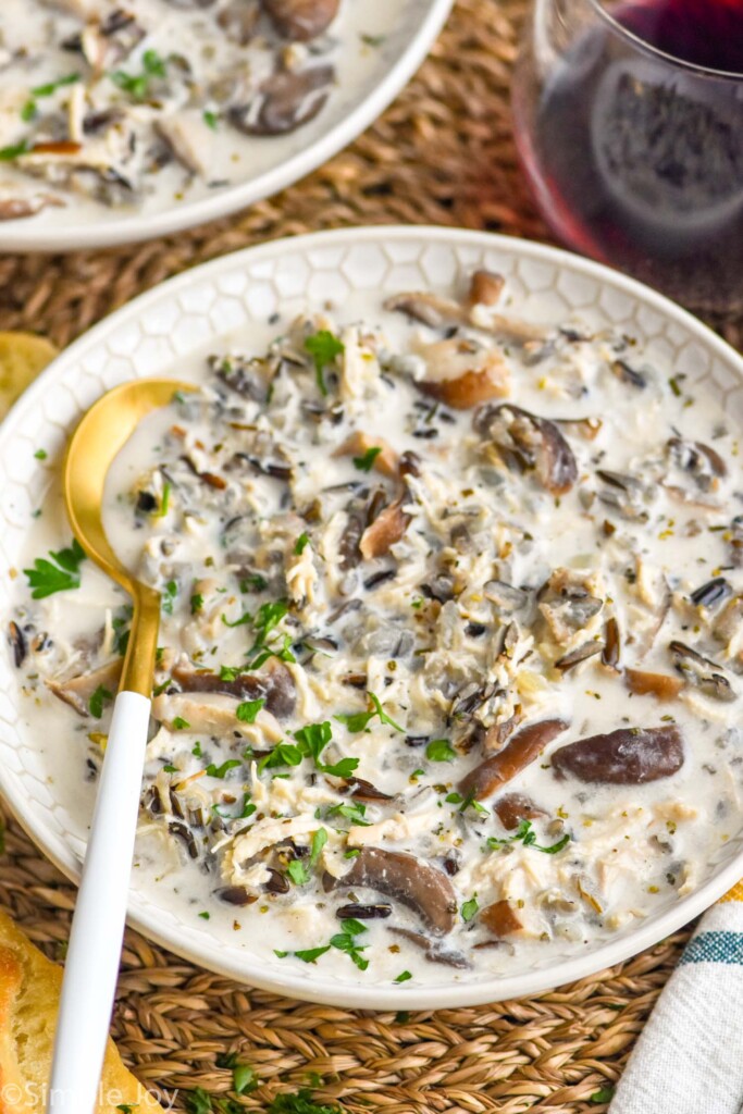 bowl of chicken and wild rice soup garnished with fresh parsley