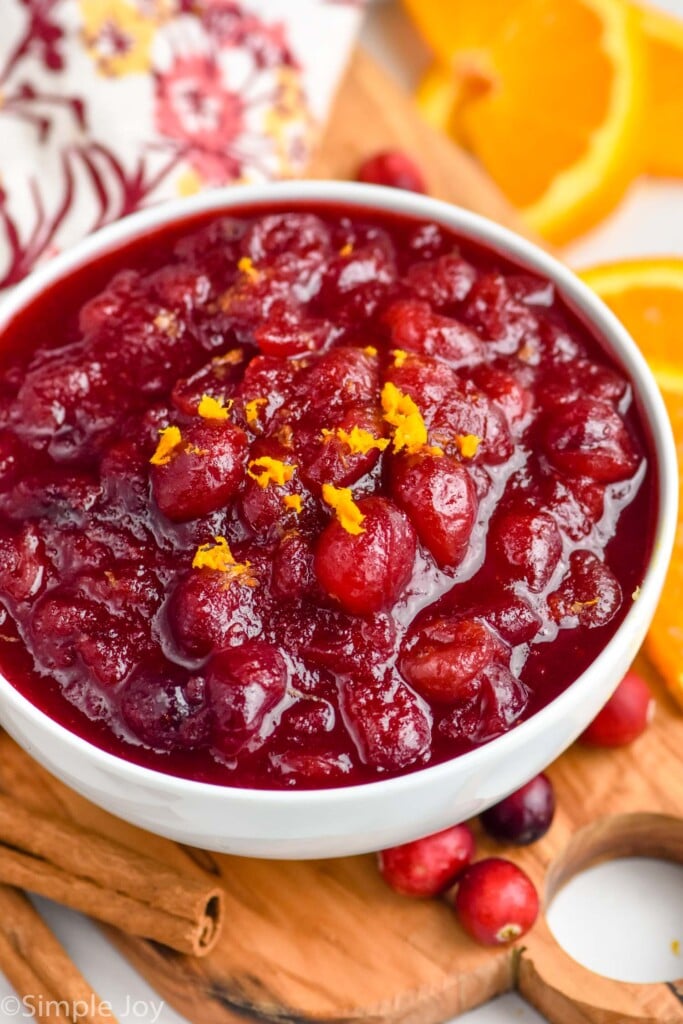 bowl of Cranberry Sauce. Fresh cranberries, orange slices, and cinnamon sticks surrounding bowl