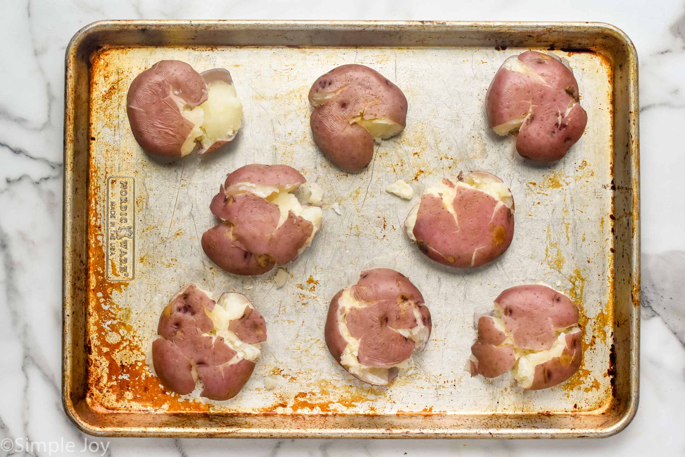 overhead of smashed potatoes on a baking sheet