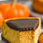 Pinterest graphic for Pumpkin Cheesecake recipe. Text says, "the best Pumpkin Cheesecake simplejoy.com." Image shows a slice of Pumpkin Cheesecake with with a bite taken out.