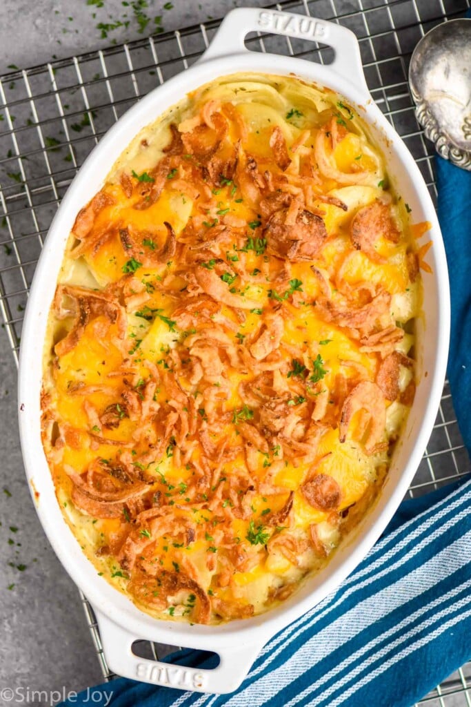 Overhead photo of a baking dish of Scalloped Potatoes on a cooling rack