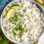 overhead of a bowl of cilantro lime rice garnished with two lime wedges and extra cilantro