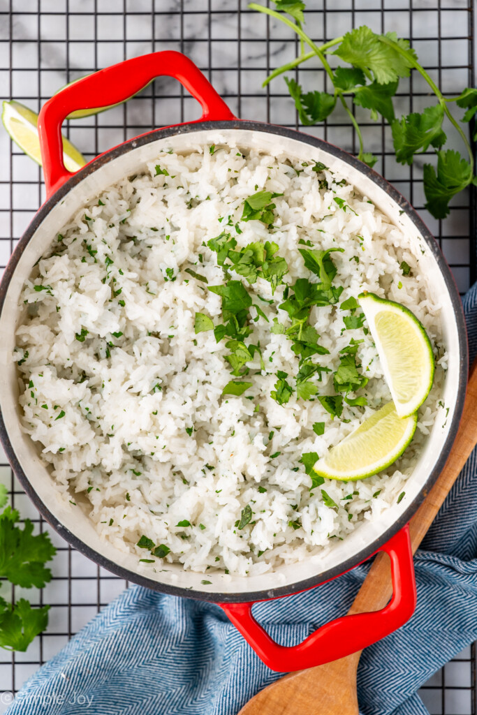 overhead of a pot of cilantro lime rice recipe garnished with two lime wedges and extra cilantro