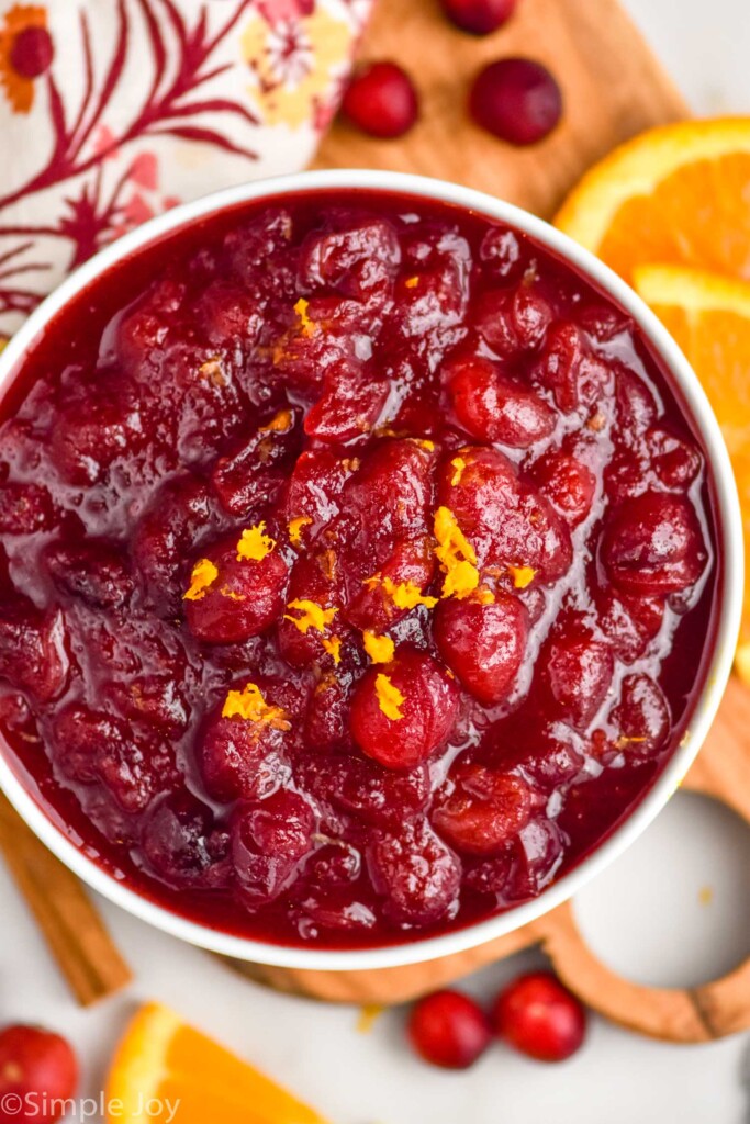 bowl of Cranberry Sauce. Fresh cranberries, orange slices, and cinnamon sticks surrounding bowl