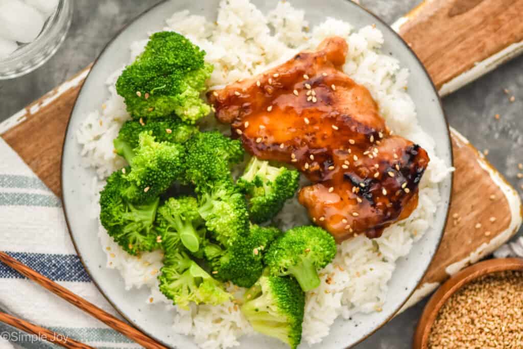 overhead of a piece of teriyaki chicken on a bed of rice with steamed broccoli