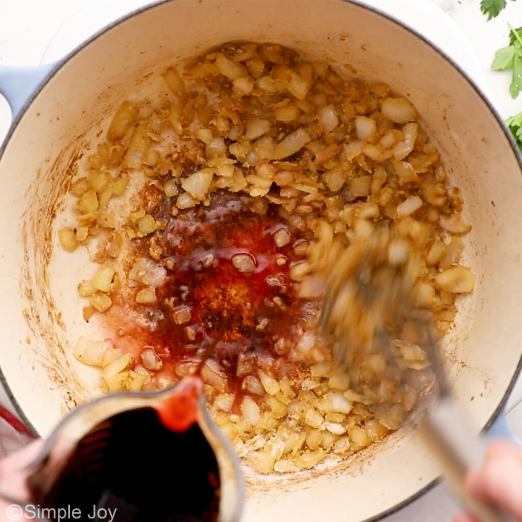 red wine pouring into a pan to deglaze a pan