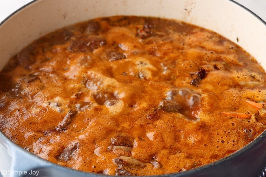 a large dutch oven with beef stew boiling