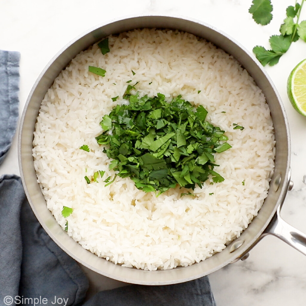 overhead of a saucepan with cooked rice and fresh cilantro