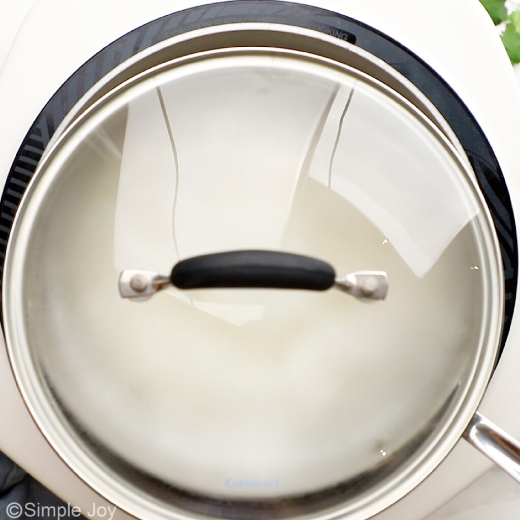 overhead of a sauce pan with the lid slightly ajar