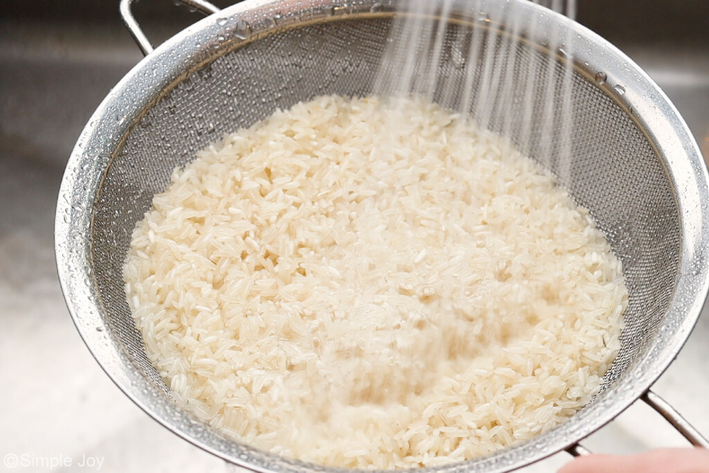 rice being rinsed in a strainer