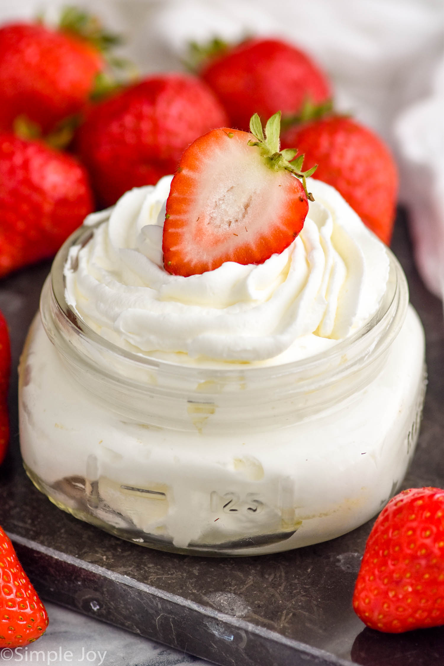 Photo of a jar of Homemade Whipped Cream with strawberries