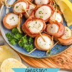 Pinterest graphic for Bacon Wrapped Scallops recipe. Image shows Bacon Wrapped Scallops on a plate with lemon wedges. Bread and wine beside. Text says, "amazing Bacon Wrapped Scallops simplejoy.com"